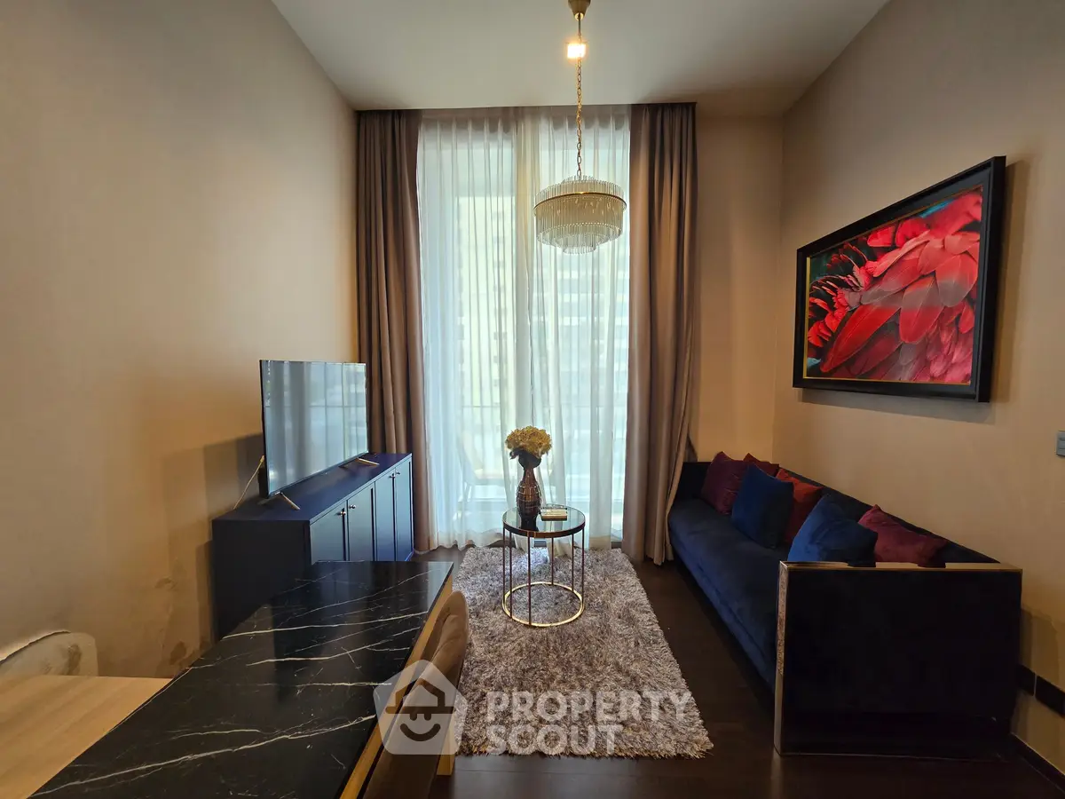 Elegant living room with modern decor, featuring a plush sofa, stylish chandelier, and large window with city view.