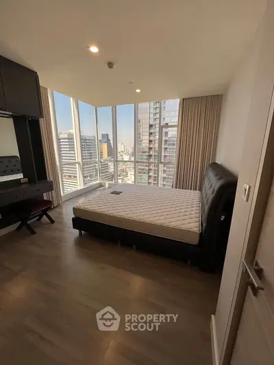 Spacious bedroom with city view and modern furnishings in high-rise apartment