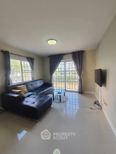 Spacious living room with modern decor and large windows for natural light.