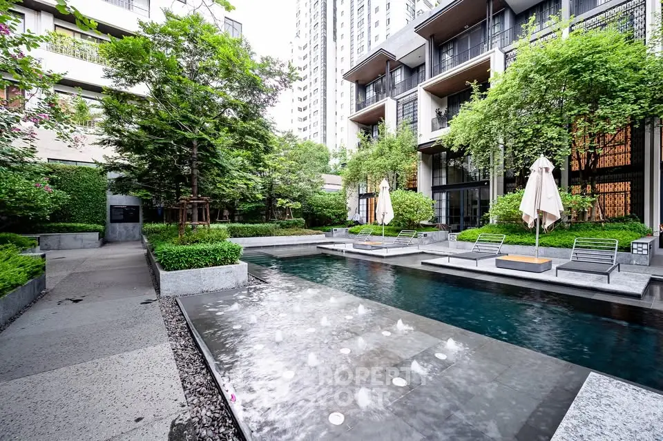 Luxurious modern apartment complex with serene pool and lush greenery