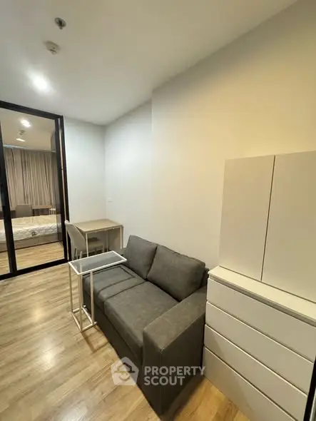 Modern living room with sleek furniture and wooden flooring in a cozy apartment.
