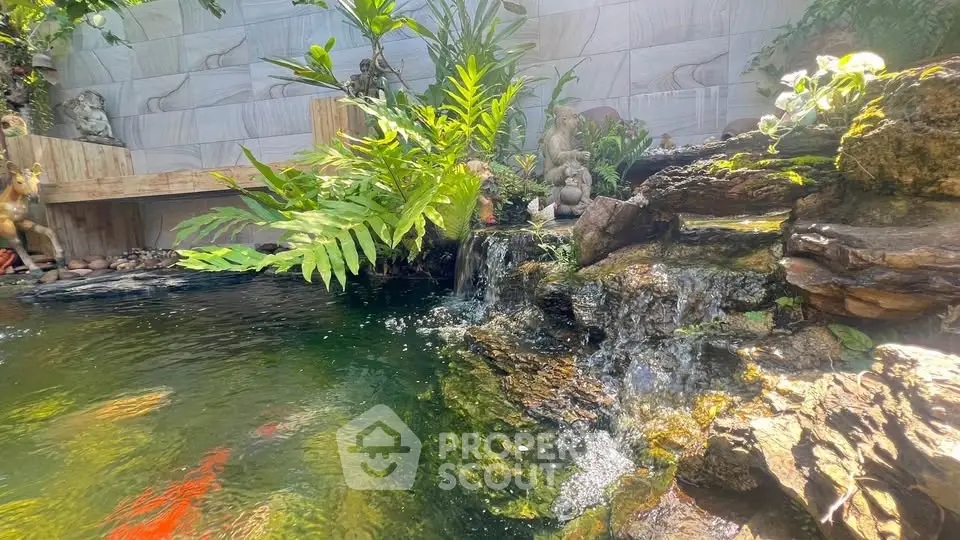 Serene garden pond with lush greenery and cascading waterfall feature.