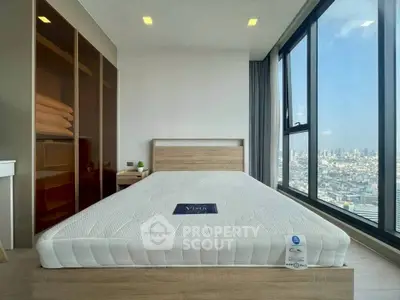 Modern bedroom with large window offering stunning city view and sleek wooden furniture.