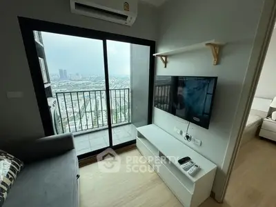 Modern living room with balcony and city view, featuring sleek TV setup and air conditioning.
