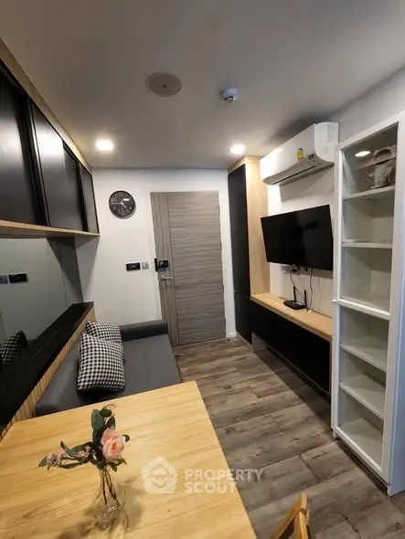 Modern living room with sleek design, featuring a wall-mounted TV, stylish furniture, and elegant decor.