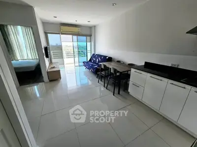 Modern open-plan living room with kitchen and balcony view