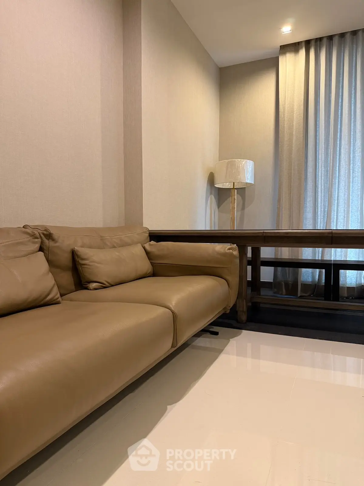 Modern living room with elegant beige sofa and stylish floor lamp, perfect for cozy relaxation.