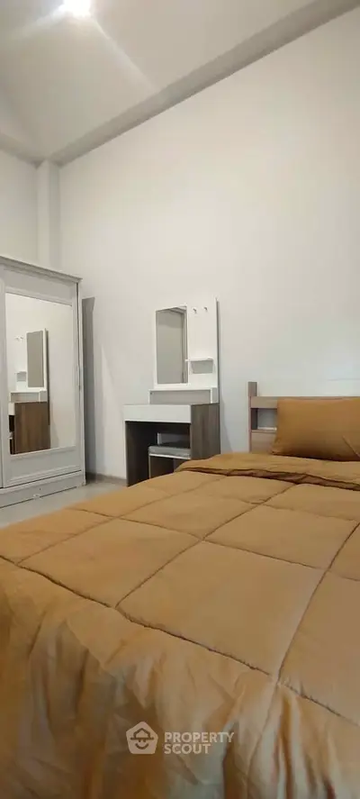 Cozy bedroom with modern furniture and warm bedding in a stylish apartment.