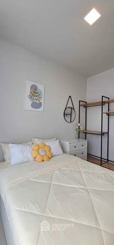 Cozy bedroom with modern decor and stylish shelving unit.