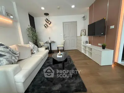 Modern living room with stylish decor, cozy seating, and sleek entertainment setup.