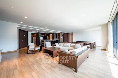 Spacious modern living room with open kitchen and elegant wooden flooring.