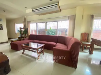 Spacious living room with large windows and comfortable seating in a modern home.