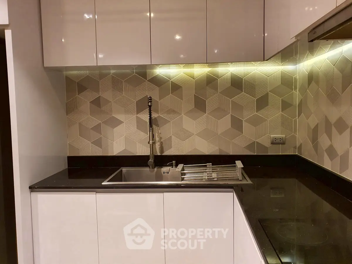 Modern kitchen with sleek cabinets and geometric backsplash