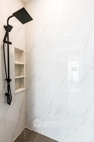 Modern bathroom with sleek shower and marble tiles, perfect for a luxurious home experience.