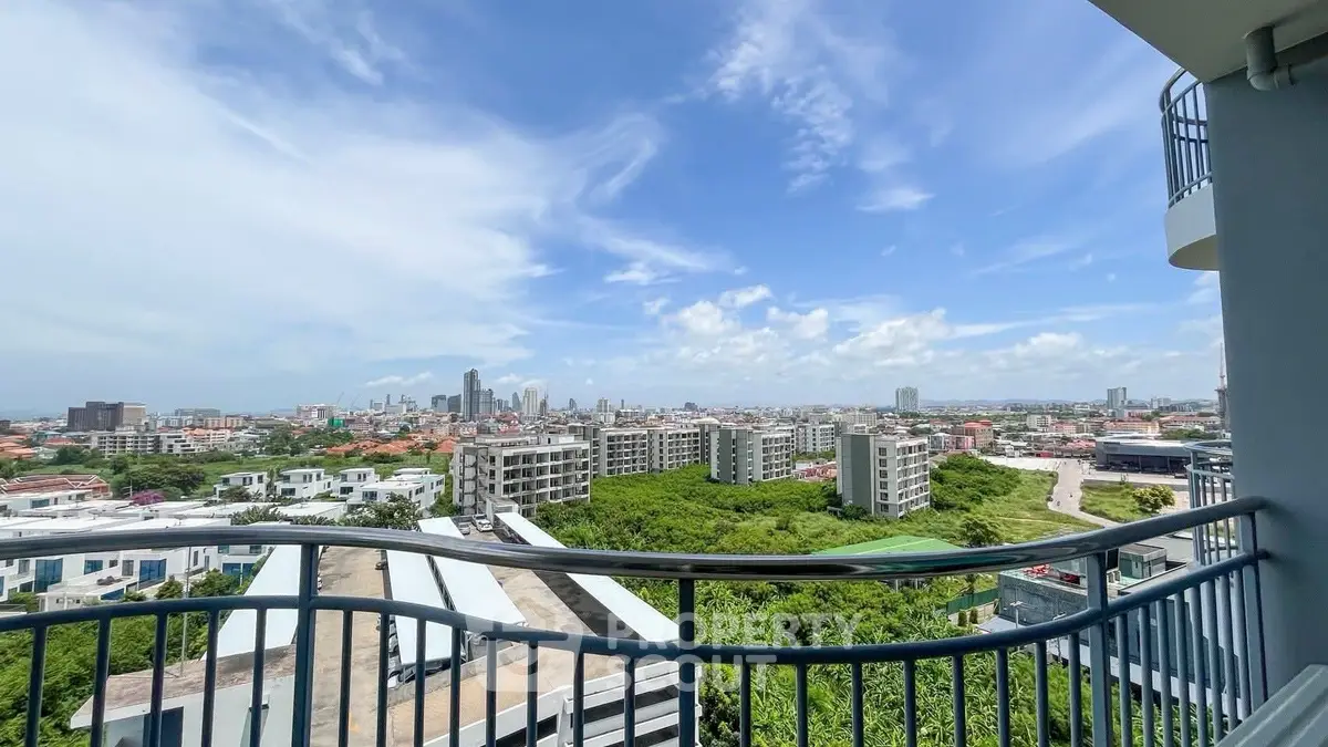 Stunning cityscape view from a high-rise balcony with clear blue skies.