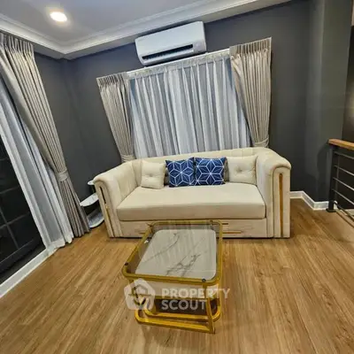 Elegant living room with plush sofa, stylish curtains, and modern air conditioning unit.