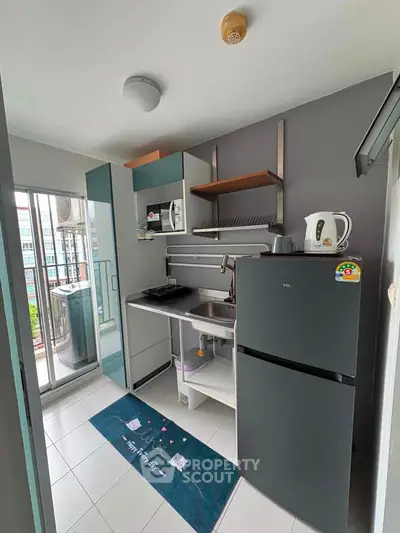 Modern compact kitchen with balcony view, featuring sleek appliances and efficient storage solutions.
