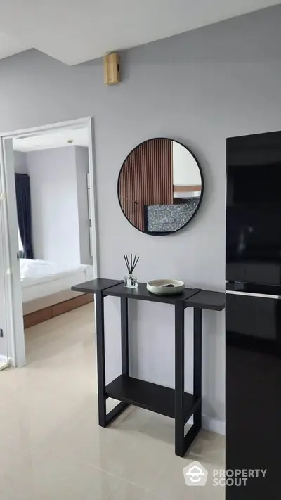 Modern interior with sleek black console table and round mirror in stylish apartment