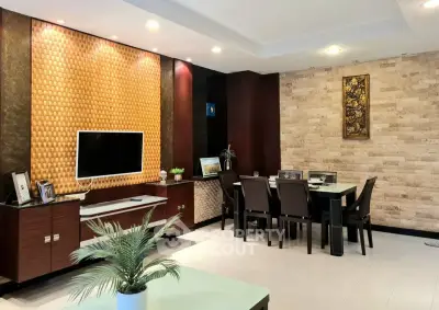 Elegant living room with modern decor and dining area, featuring stylish lighting and textured walls.