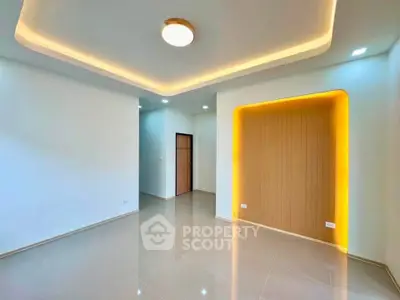 Modern minimalist living room with recessed lighting and sleek tile flooring.