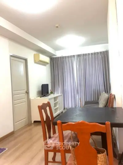 Cozy living room with dining table and natural light, perfect for relaxation.