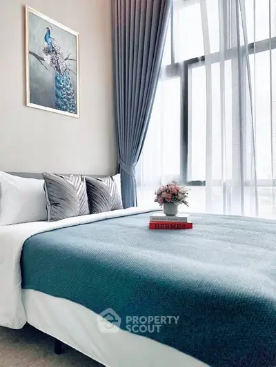 Elegant bedroom with modern decor, featuring a stylish bed, large window, and chic artwork, perfect for relaxation.