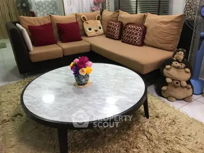 Charming living room with cozy sectional sofa and elegant marble coffee table.