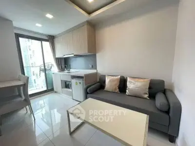 Modern living room with sleek kitchen and balcony access in urban apartment