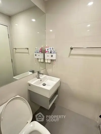 Modern bathroom with sleek fixtures and wall-mounted sink in a minimalist design.