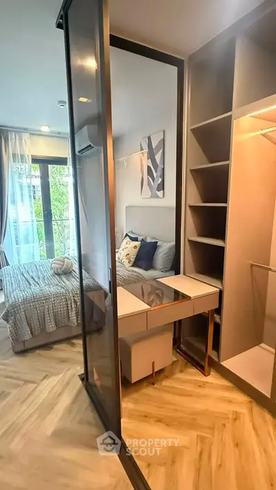 Modern bedroom with stylish decor and built-in closet, featuring a cozy bed and natural light.
