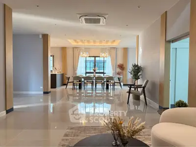 Luxurious open-plan living and dining area with elegant decor and modern lighting.