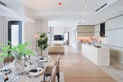 Luxurious open-plan living and dining area with modern kitchen in elegant apartment.