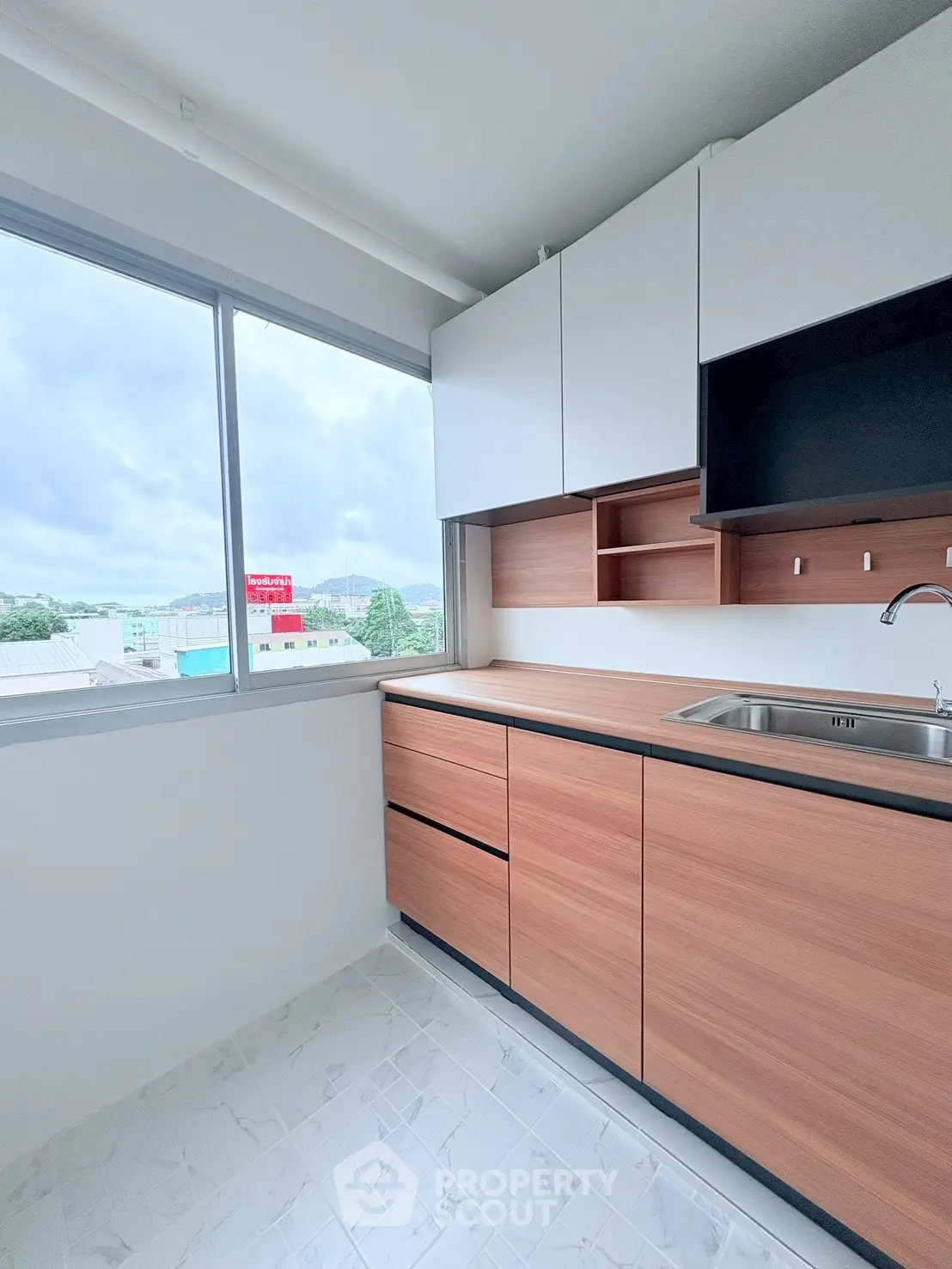 Modern kitchen with sleek cabinets and large window offering natural light