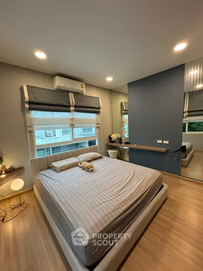 Modern bedroom with stylish decor and large windows offering natural light.