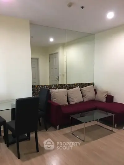 Modern living room with stylish red sofa and glass coffee table in cozy apartment.