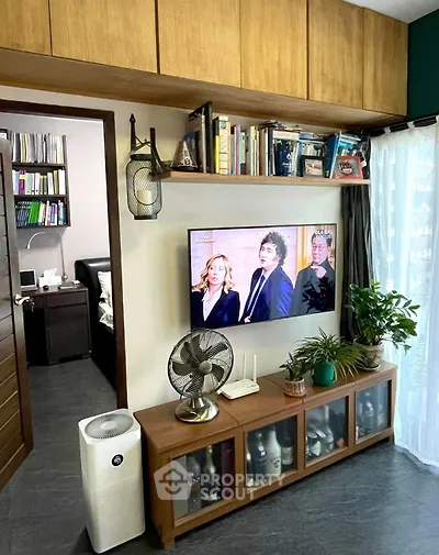 Modern living room with stylish decor, wall-mounted TV, and ample storage space.