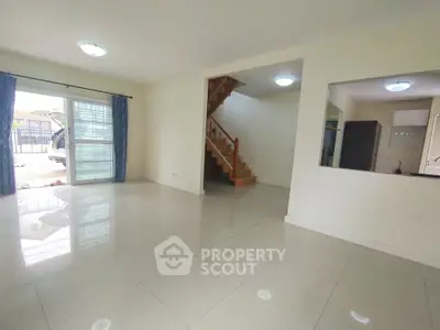 Spacious open-plan living area with staircase and large windows