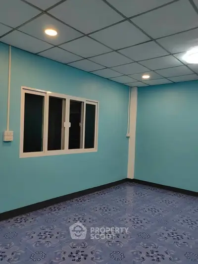 Spacious room with blue walls and patterned tile flooring, ideal for versatile interior design.