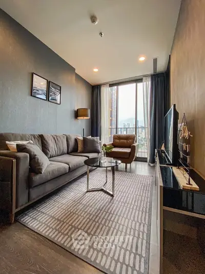 Modern living room with stylish decor and large window offering city view.