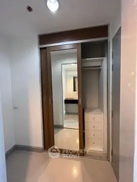 Modern closet with sliding mirror doors in a sleek interior space.