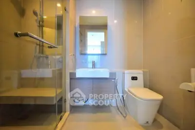 Modern bathroom with glass shower and sleek fixtures in contemporary apartment.