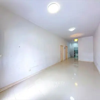 Spacious empty room with glossy tiled floor and bright lighting, ideal for customization.