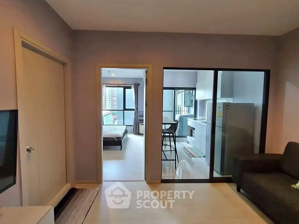 Modern apartment interior with open layout, featuring a cozy living room and a glimpse of the bedroom.
