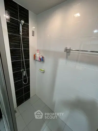 Modern bathroom with sleek shower and tiled walls, perfect for a contemporary home.