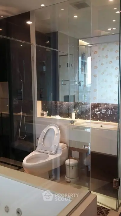 Luxurious modern bathroom with glass shower and elegant fixtures.