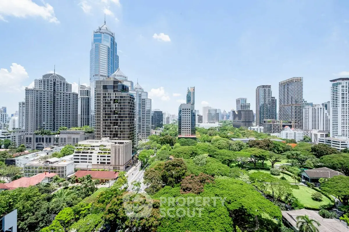 Stunning cityscape view with lush greenery and modern skyscrapers under a clear blue sky.