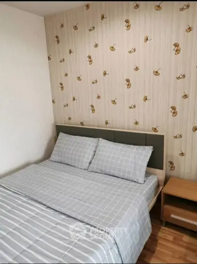 Cozy bedroom with stylish wallpaper and modern bedding in a real estate property.