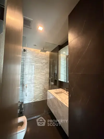 Luxurious modern bathroom with marble sink and glass shower enclosure