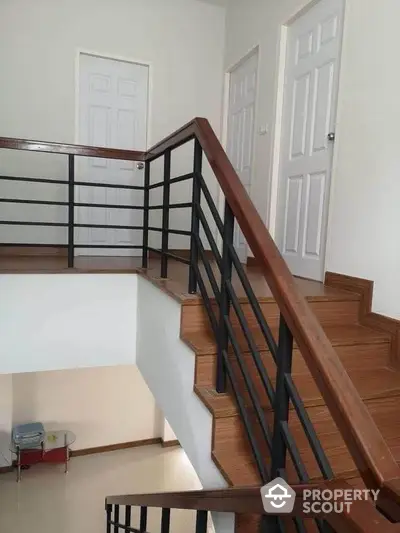 Modern staircase with wooden steps and metal railing in a contemporary home interior