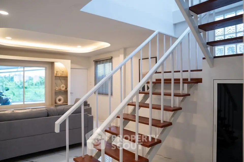 Modern living room with stylish staircase and large window view